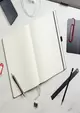 offner Notizblock liegt auf einem Schreibtisch 